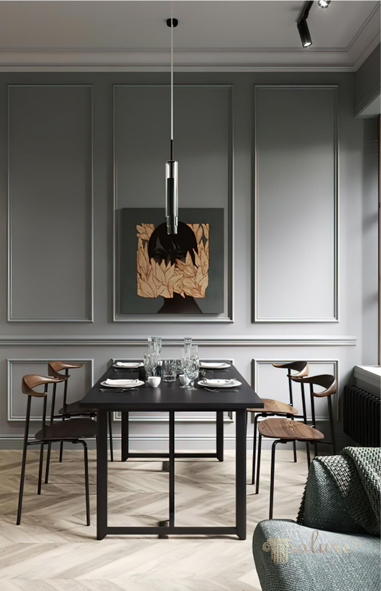 Slate grey dining room wall with wainscoting frames, artwork, black dining table, and light wooden herringbone floor.