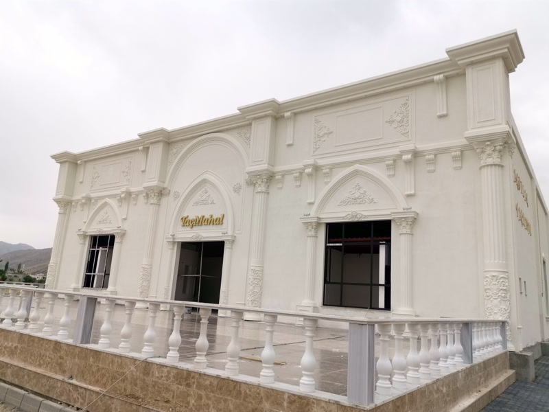 Palace style building facade in Kahramanmaraş with a white balustrade terrace railing and pointed arched windows.