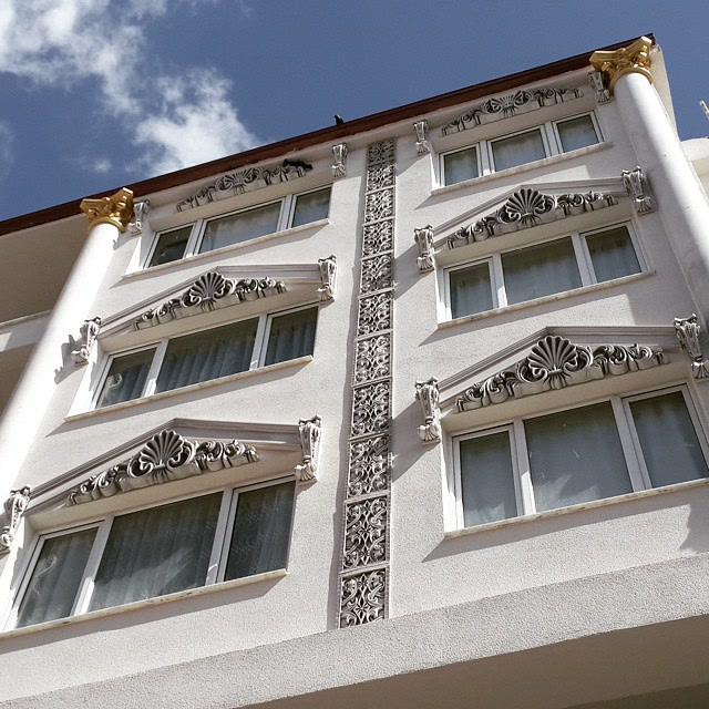 White Residential Facade with Shell Window Pediments