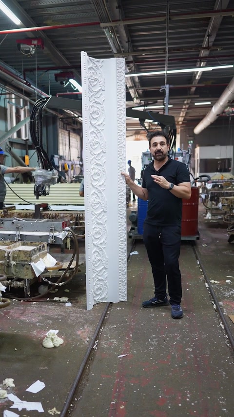 Vært viser den komplette mønstrede stukliste i fuld længde på fabriksgulvet