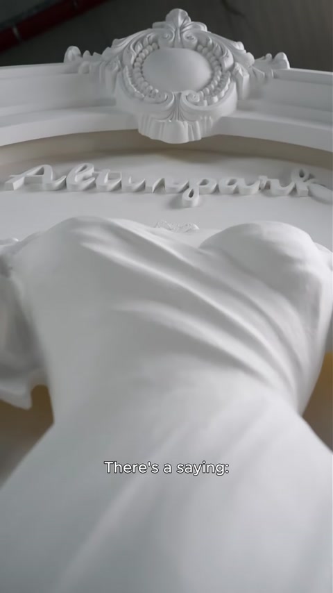 Pormenor dos vincos esculpidos do tecido do vestido de noiva em poliuretano branco.