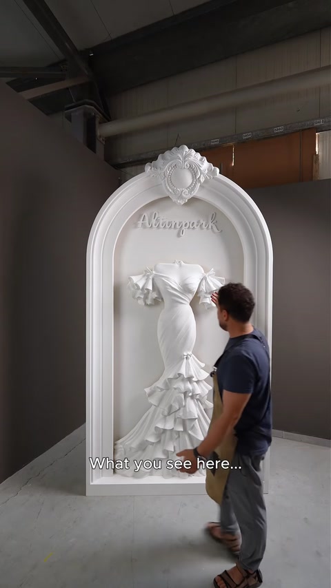 Arco de poliuretano montado com relevo do vestido de noiva num ambiente de fábrica.