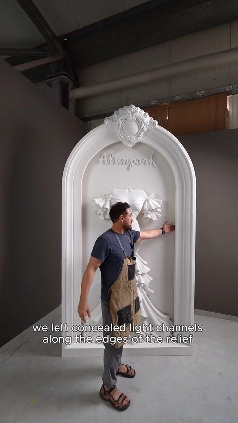 Artesão junto ao arco acabado a explicar os canais de luz LED ocultos atrás do relevo.