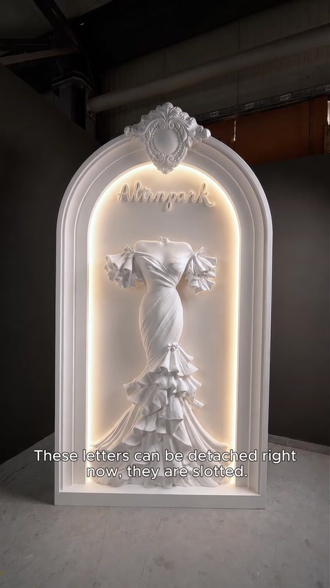 Arco iluminado com o nome da boutique aceso e o relevo do vestido retroiluminado.