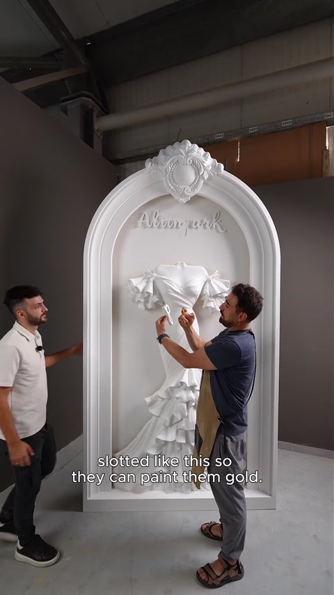 Dois homens retiram as letras encaixadas do painel de relevo do arco.