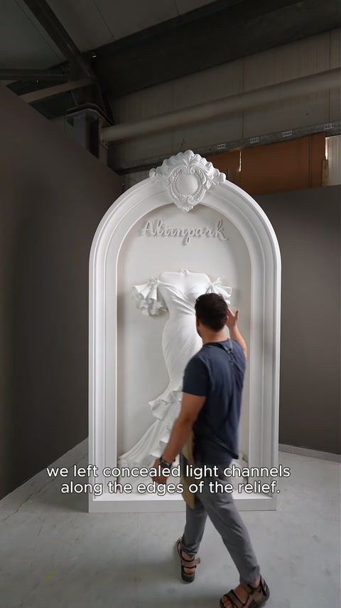Artesão indica os caminhos de iluminação ocultos que circundam a decoração de vestido de noiva elevado.