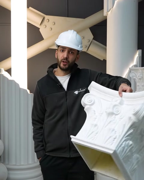 Employee presents white polyurethane cornice molding near columns