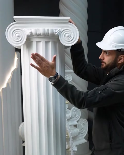 Staff member gestures beside tall fluted Ionic polyurethane column