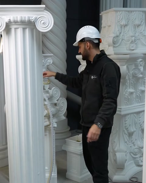 Employee examines carved capital detail on polyurethane column