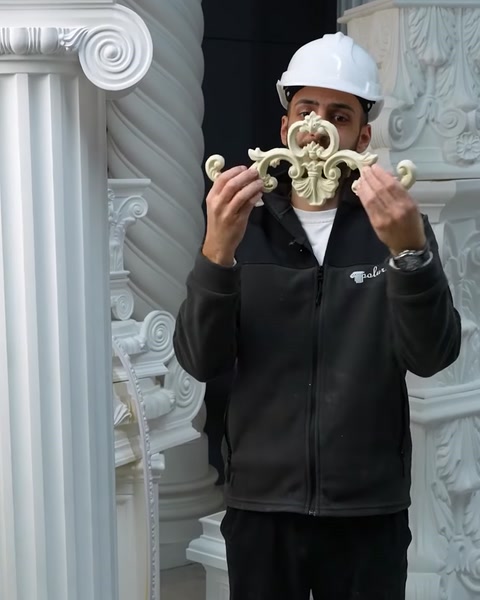 Employee holds ornate polyurethane acanthus scroll applique piece