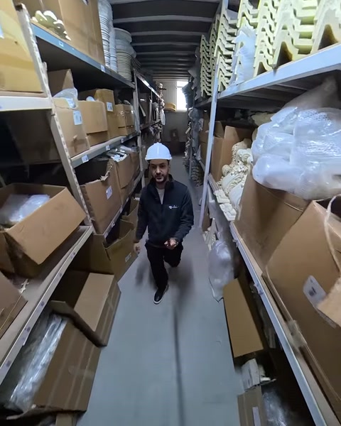 Employee walks warehouse aisle lined with packaged polyurethane products