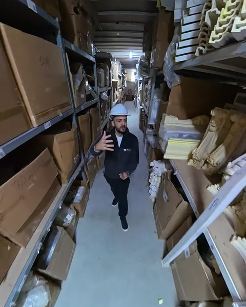 Employee speaks to camera walking through polyurethane storage warehouse