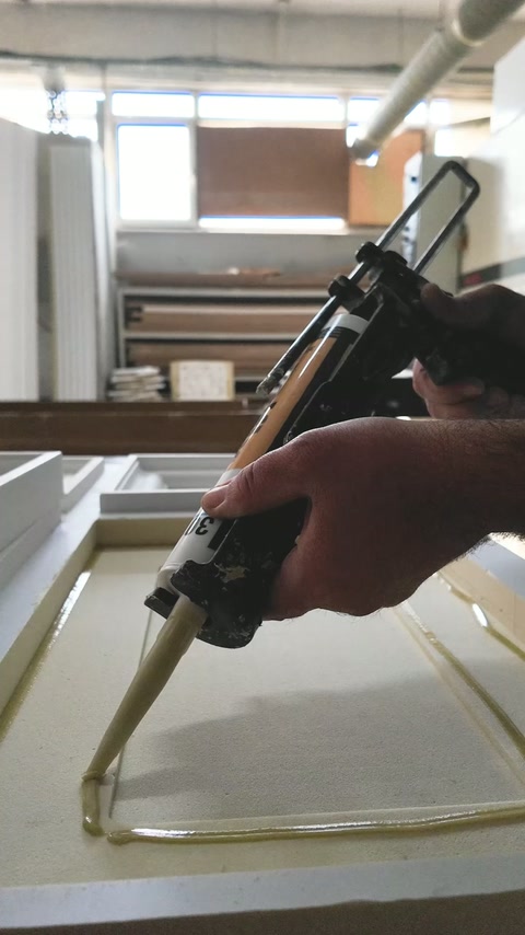 Kolem zapuštěného obdélníkového panelového prvku se nanáší lepidlo