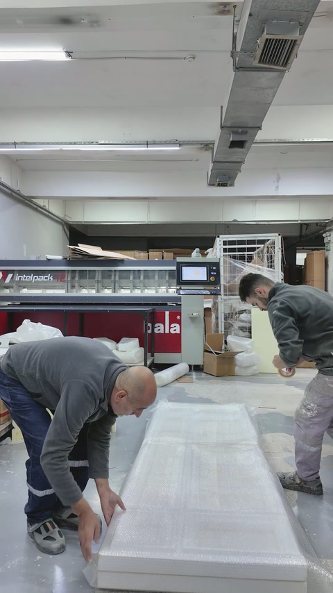 Pracovníci upevňují ochranný materiál kolem dokončeného dekorativního panelu