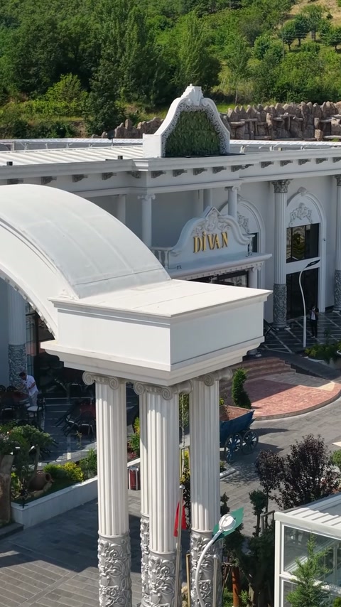 Une canopée d'entrée courbe combine des corniches, des colonnes et des détails de toit décorativement