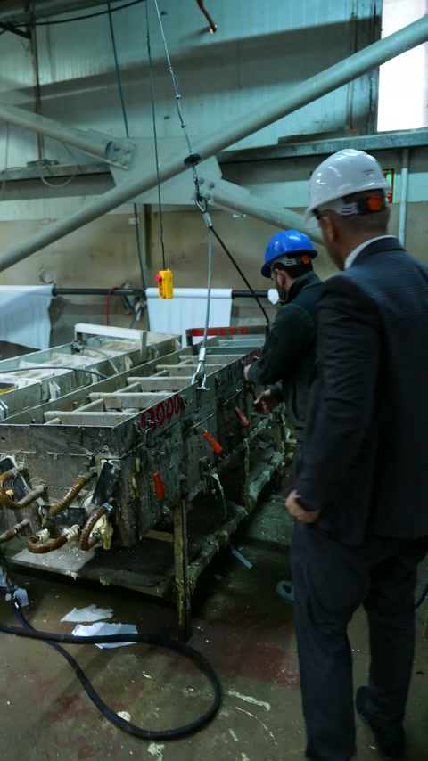 Les ouvriers de production font fonctionner la machinerie le long d'une ligne de moulure en polyuréthane