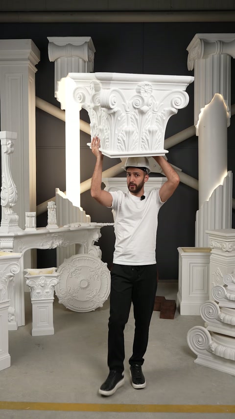 Un artisan présente un grand chapiteau corinthien à l'intérieur de la salle de production