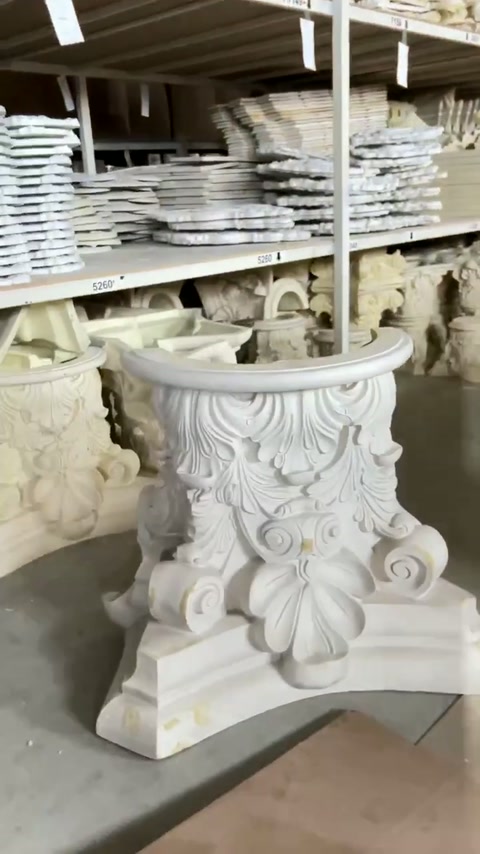 Les chapiteaux décorativement finis sont organisés sur des étagères de stockage d'atelier