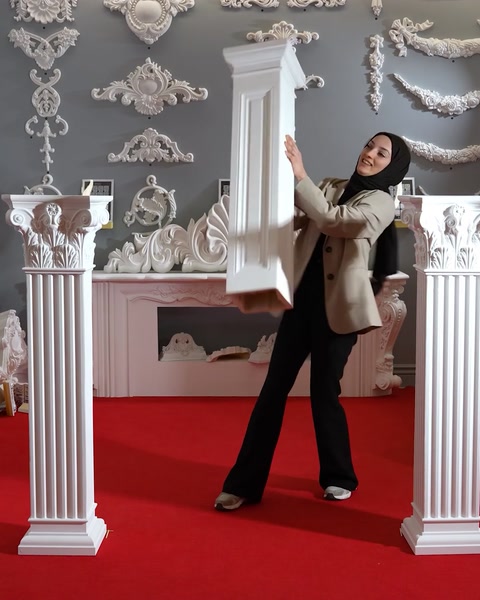 Woman holding a tall polyurethane pedestal column upright
