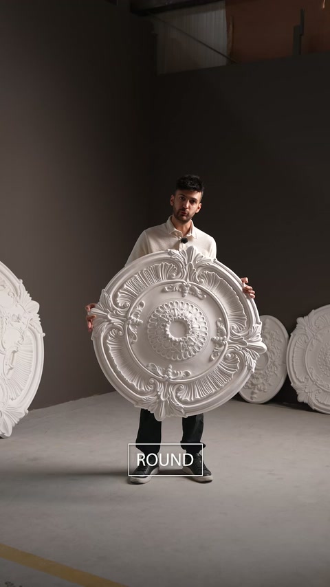 Le présentateur montre un grand médaillon de plafond rond en polyuréthane dans le showroom.