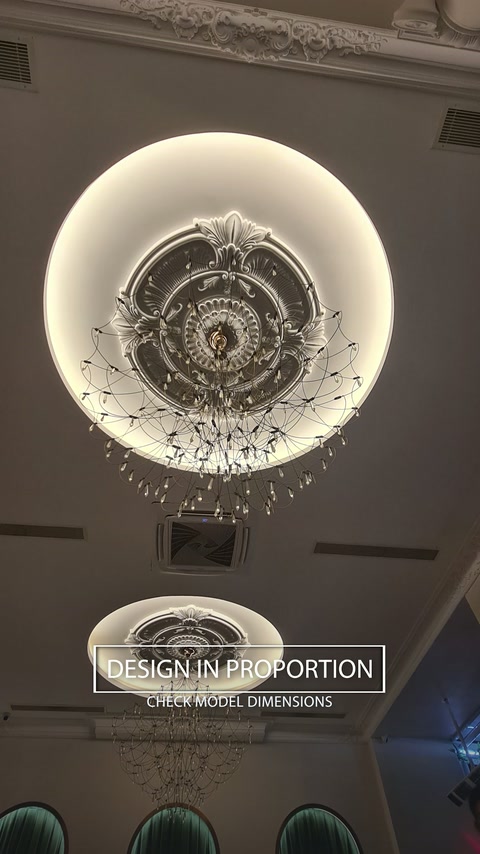 Une vue large du plafond montre les proportions du médaillon autour du lustre suspendu.