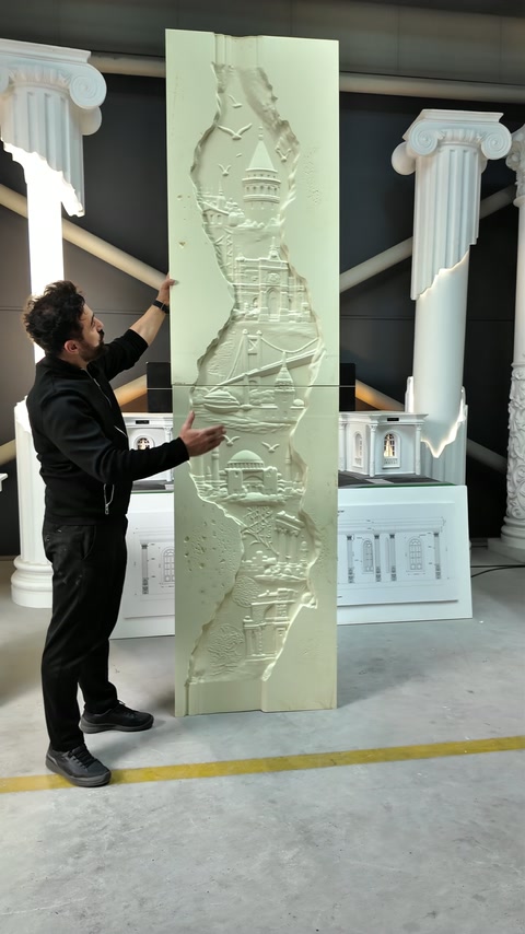 Le présentateur désigne les détails du grand panneau mural sculpté