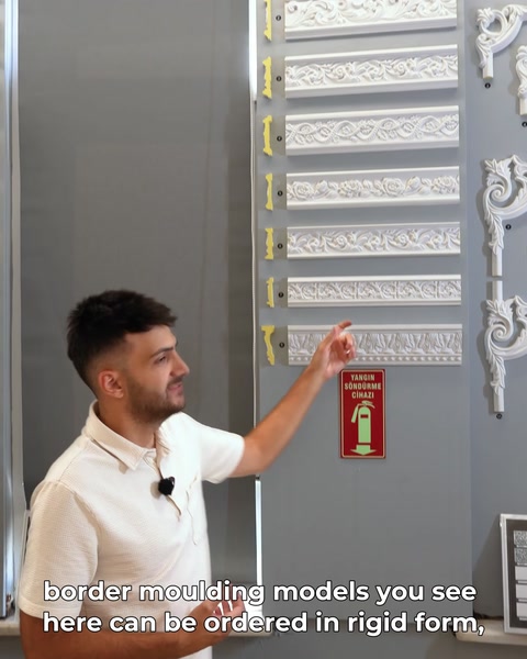 Presenter points to rows of border moulding designs on display