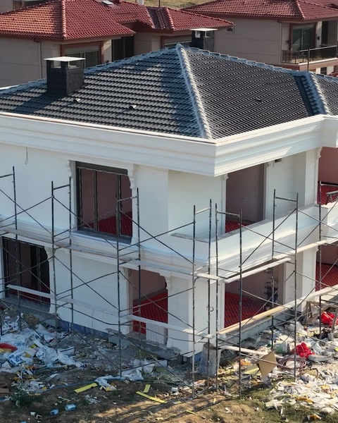 Hotový exteriér vily ukazující sloupy a římsou ze vzdálenosti