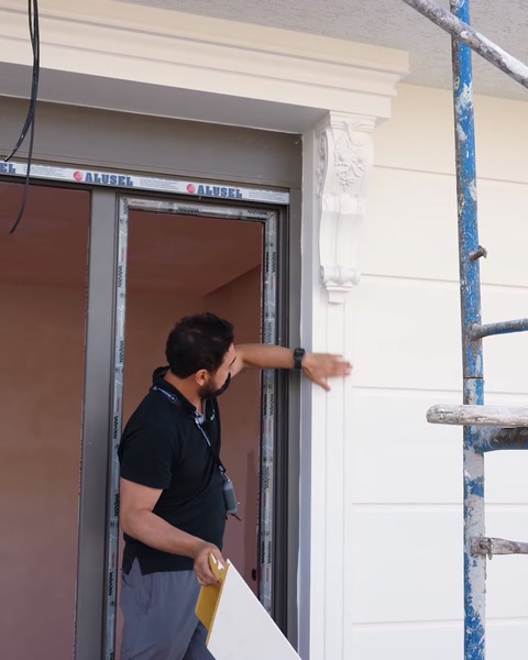 Pracovník testující nainstalovaný nátěr okna na odolnost rukou