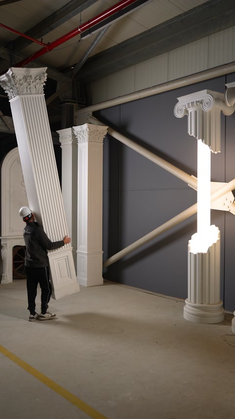 Ouvrier transportant une colonne en polyuréthane dans l’atelier de production