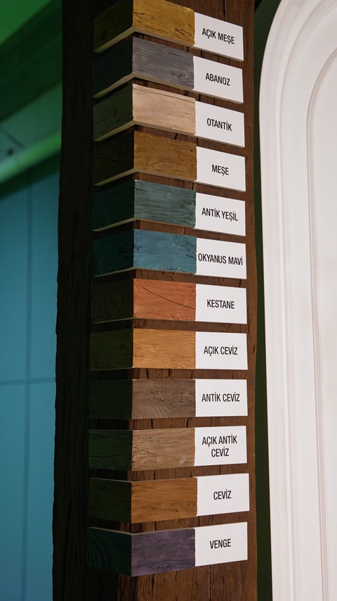 Nuanciers de couleurs de bois étiquetés disposés sur un panneau vertical