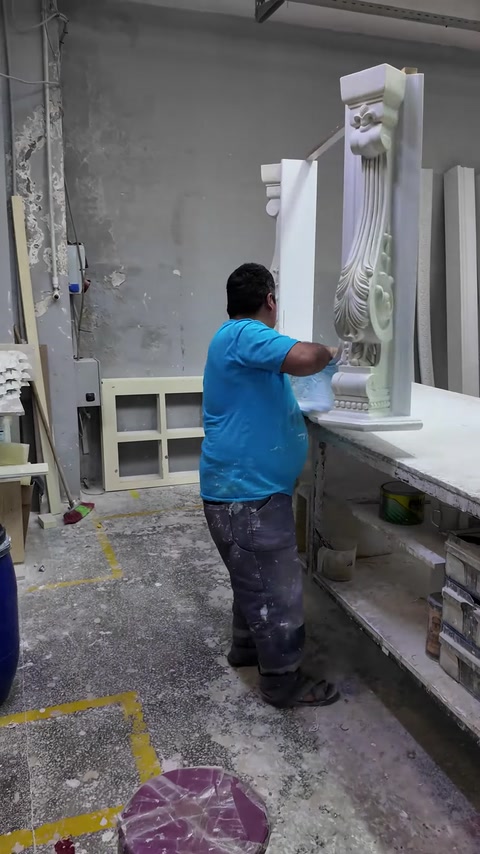 Pracovník nanáší finální vrstvu na vzpřímený dekorativní pilastr.