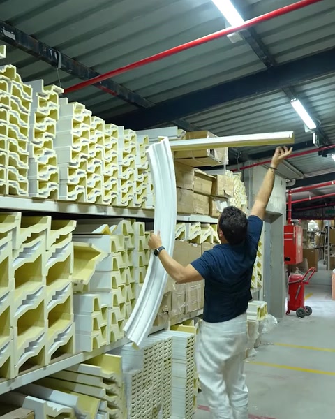 Mand løfter en oprullet fleksibel liste fra lagerreolen