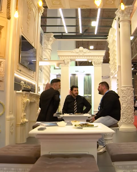 Staff members seated at meeting table inside exhibition stand