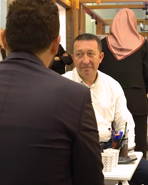 Three colleagues seated discussing business at exhibition table
