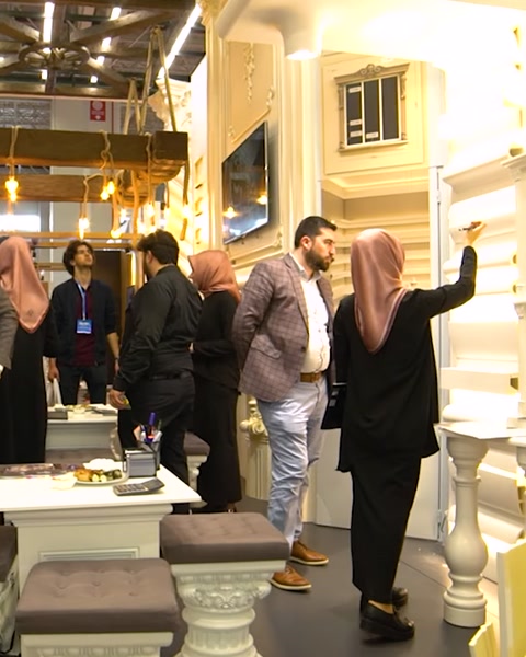 Group of visitors walking through decorated exhibition stand aisle