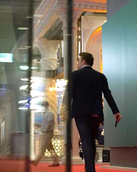 Man walking past illuminated glass panel exhibition display