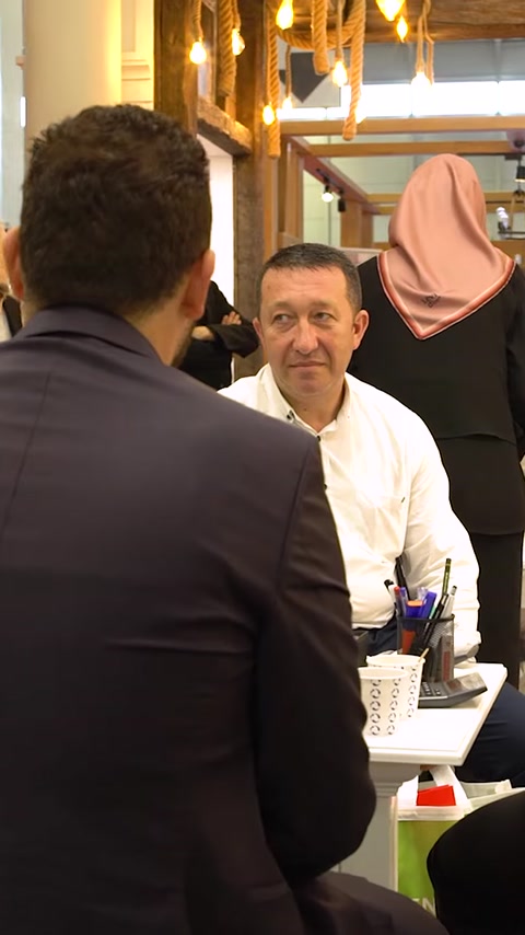 Tre kolleger sidende der diskuterer forretning ved messestanden