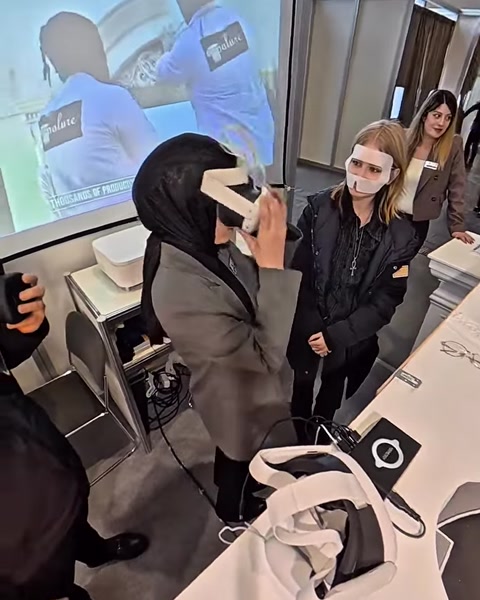 Žena používá VR brýle, na blízké obrazovce jsou vidět virtuální sloupy