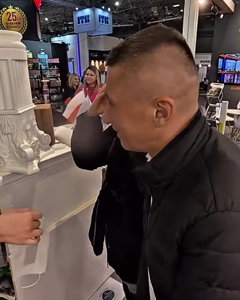 Muž zblízka zkoumá povrchovou texturu polyuretanového sloupu na stánku
