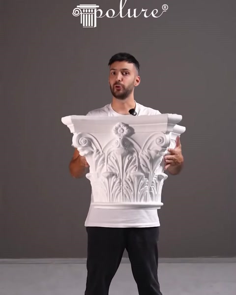 Il presentatore tiene in mano un capitello di colonna decorativo intagliato