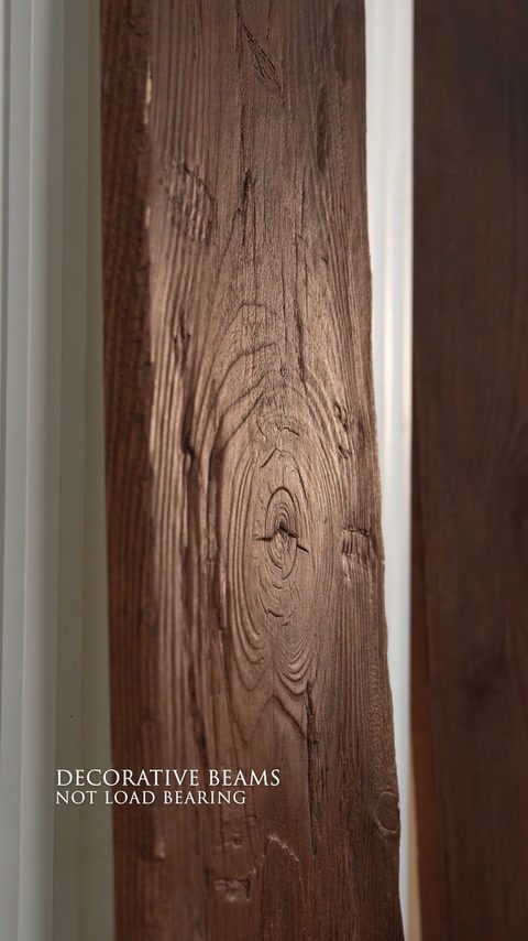 Un gros plan d’une poutre décorative brune met en valeur les nœuds et le veinage fluide.