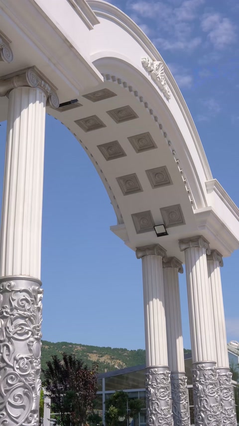 Der geschwungene Eingangsbogen zeigt eine kassettierte Gestaltung und eine verzierte Säule.