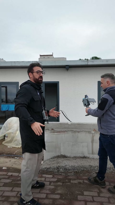 Deux membres de l’équipe préparent le matériel de numérisation portatif à l’extérieur du bâtiment.
