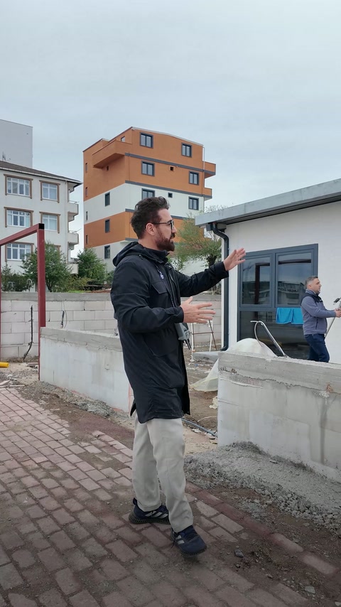 Le présentateur explique le relevé extérieur près des fenêtres et des murs de clôture.