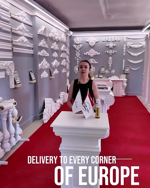 Celkový pohľad na showroom s balustrádami a piliermi pozdĺž červeného koberca