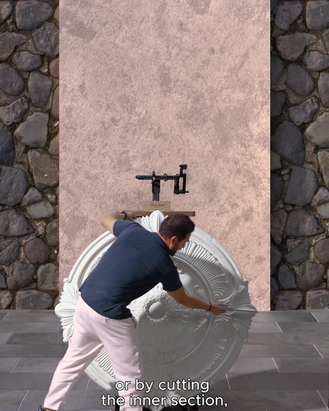 Pracovník vyřezává vnitřní část bílé rozety pro instalaci na stěnu