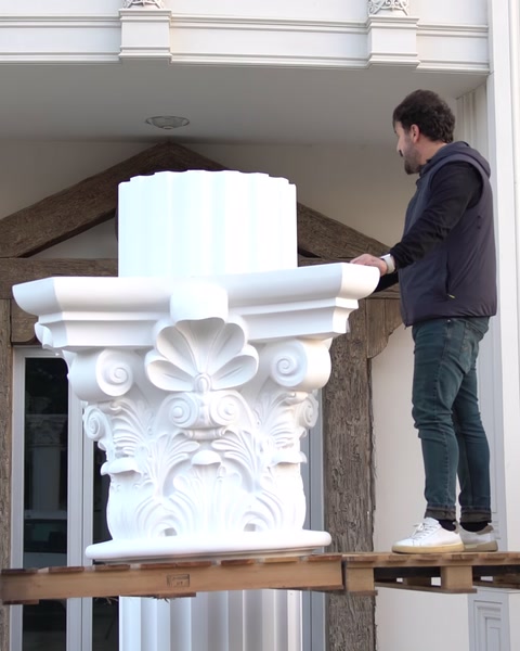 Pracovník na zvýšené platformě umisťuje hlavici na sloup.