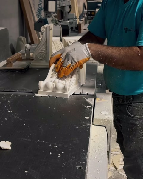 Mains détaillant un chapiteau de colonne sculpté à l'aide d'outils