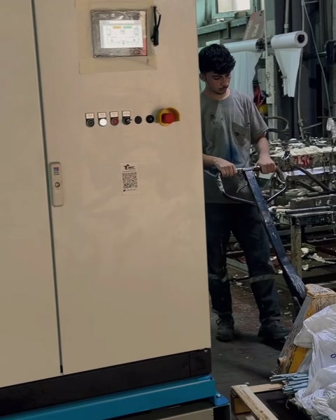 Ouvrier actionnant un panneau de commande sur la ligne de dosage de coulage